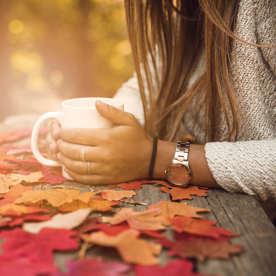 Femme avec une tasse sur fond d'automne